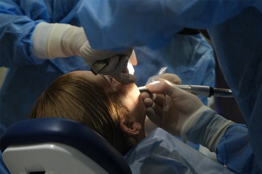 Dentist performing oral surgery