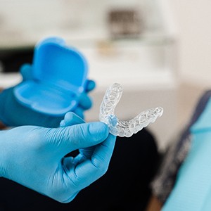 Dentist handing clear aligner to patient