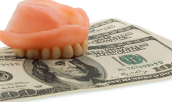 dentures on top of 3 hundred dollar bills