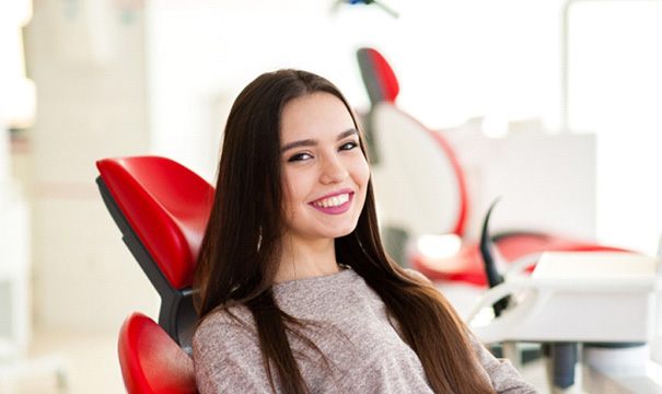 young woman smiling in dental chair