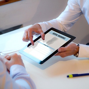 businessman looking at dental insurance forms on a tablet