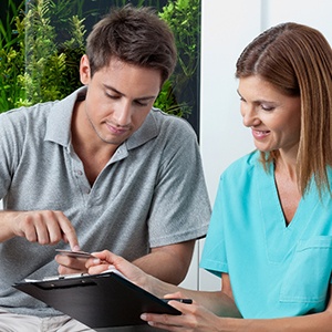 A dentist helping a patient with the cost of emergency dentistry in Attleboro