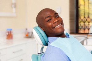 Man in blue shirt smiling before dental checkup