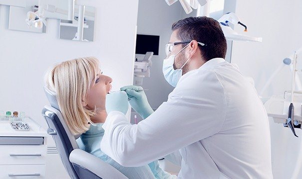 Blonde woman getting tooth extracted