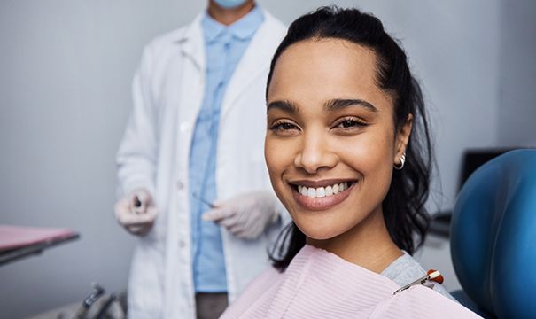 woman smiling while sitting in dental chair  