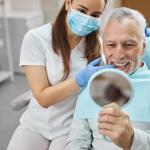 a patient checking his teeth with a mirror