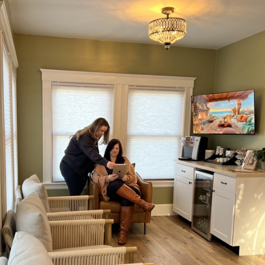 Dental team member at front desk smiling at a patient