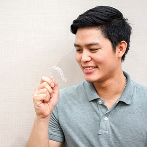 Young man holding Invisalign tray