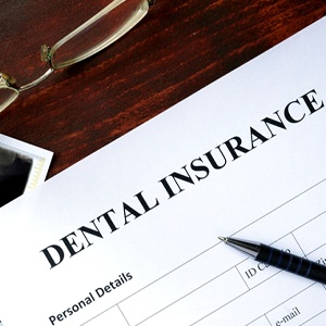 Dental insurance paperwork on desk with X-Ray and glasses