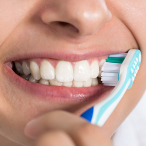 a person brushing her teeth at home