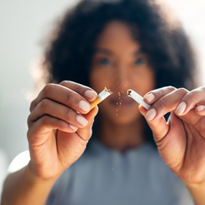 a person breaking a cigarette in half
