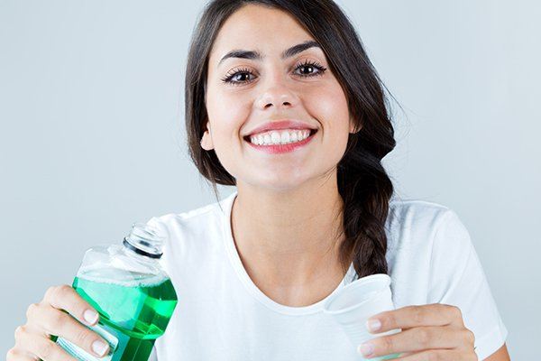 woman using mouthwash