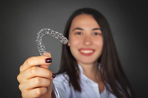 Woman holding up a clear aligner tray