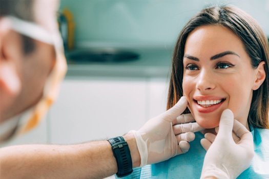 Dentist looking at smiling patient's teeth