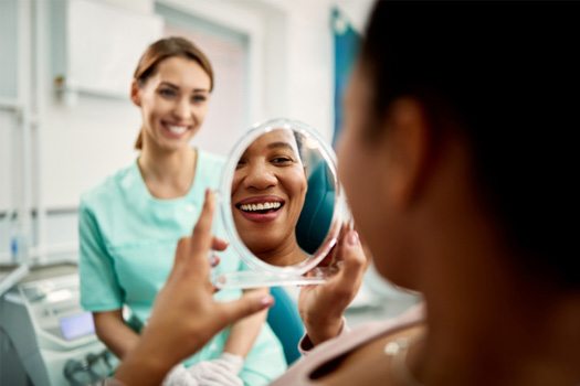 Patient smiling at reflection in treatment chair