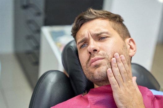 Patient with toothache sitting in treatment chair