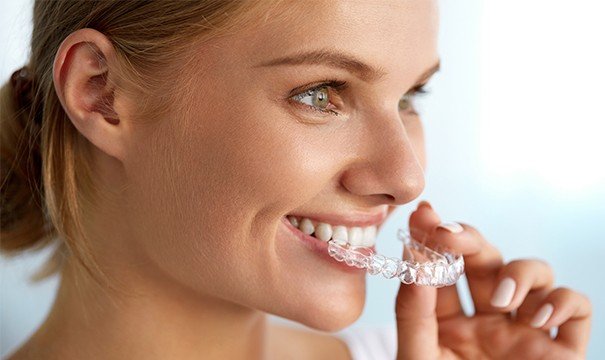 woman putting in invisalign tray