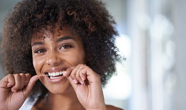 woman flossing teeth