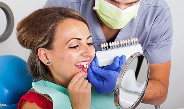 woman in red shirt trying on veneers