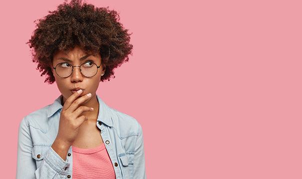 Woman on pink background wondering about veneers in Attleboro 