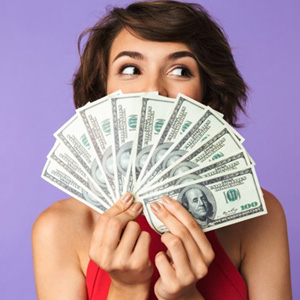Woman hiding her smile behind a fan of bills