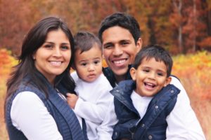 family of four smiling and embracing