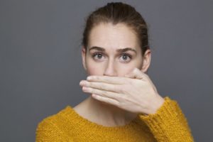 woman covering her mouth bad breath