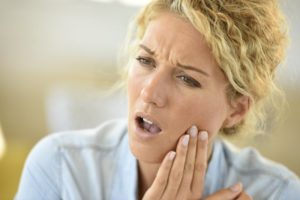 Woman cradling her aching mouth