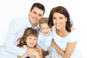 Young family smiling after seeing dentist in Attleboro.