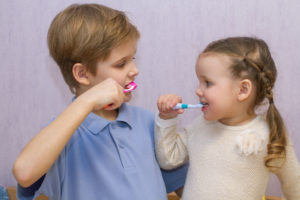 Children clean teeth with brushing tips from their dentist.