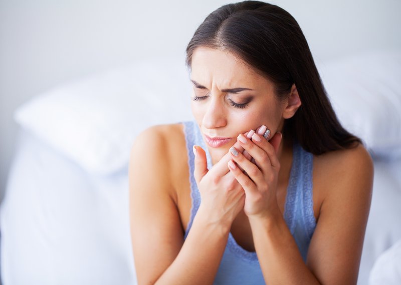 Woman experiencing tooth sensitivity  