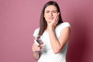 woman cringing from sensitive tooth pain