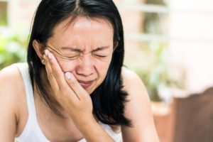 woman experiencing jaw pain and COVID