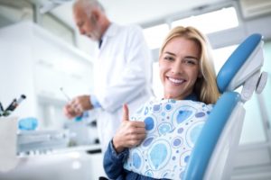 woman giving thumbs up before dental implant surgery