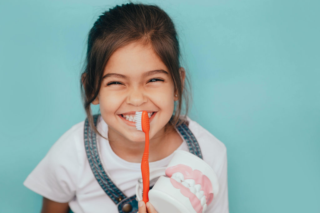 child brushing their teeth with their parents